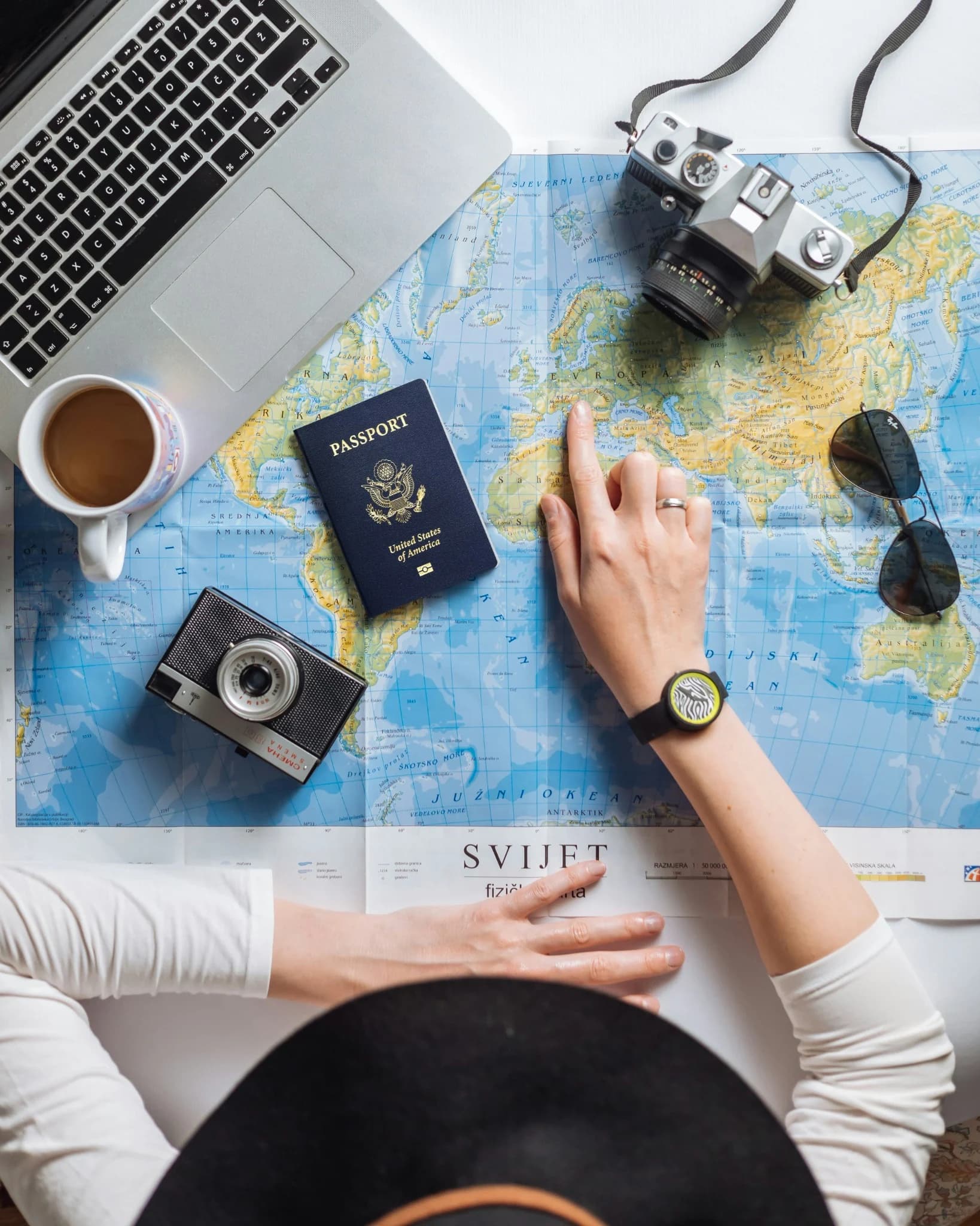 US passport and travel accessories on a map